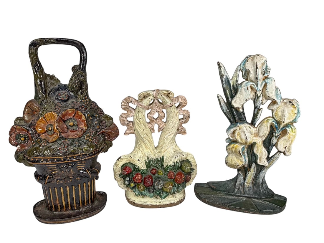 Cast Iron Floral Figural Doorstops 3pc LOT: Group of three cast iron figural doorstops. Includes a floral urn example with polychrome decoration, a white iris bouquet form, and a floral basket example with multicolor painted accents. All retain