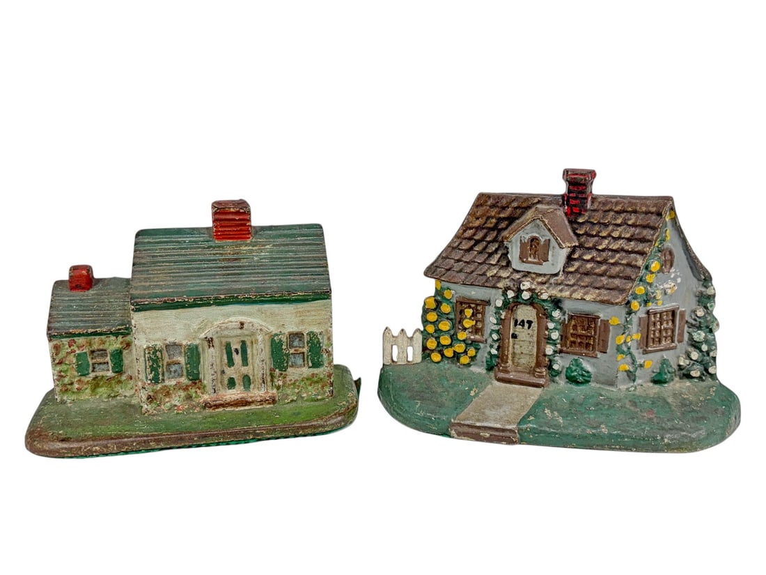 Cast Iron Figural Cottage Form Doorstops 2pc LOT: Group of two vintage cast iron cottage form doorstops with hand-painted polychrome finishes. Includes one cottage example with floral landscaping and white picket fence, together with one ranch style 