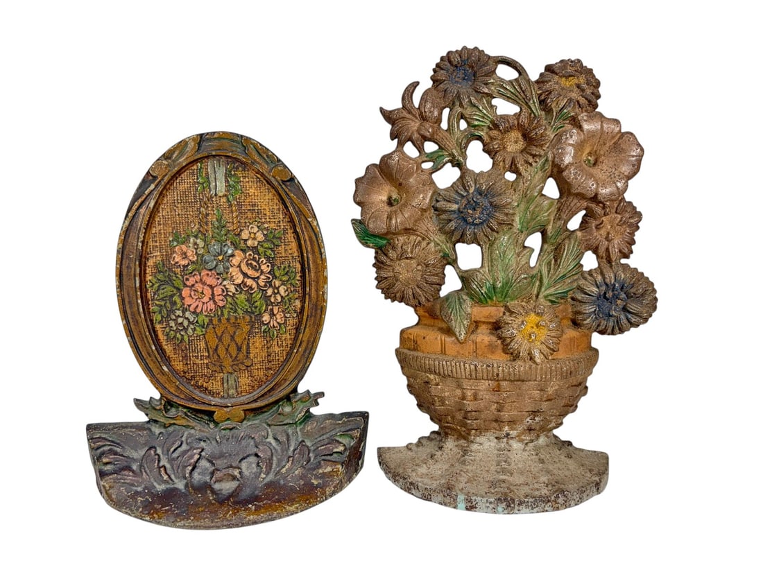 Cast Iron Figural Floral Bouquet Doorstops 2pc LOT: Group of two vintage cast iron floral form doorstops with painted finishes. Includes an openwork floral bouquet in basket form and an oval floral plaque example with molded flower basket decoration.