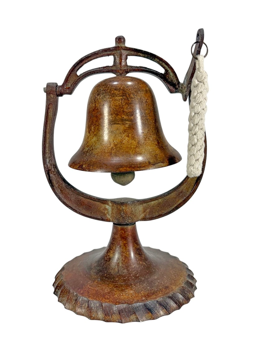 Antique Cast Iron Tabletop Dinner Bell Sculpture: Antique cast iron tabletop dinner bell featuring a swinging bell form suspended within an arched frame over a scalloped circular base. Retains original clapper and braided pull cord. Displays an aged