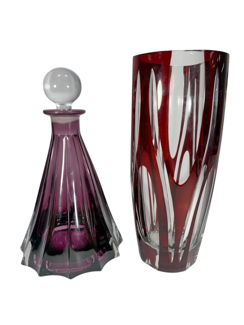 Czech Amethyst & Burgundy Crystal Decanter & Vase: Czechoslovak cut crystal two-piece lot comprising an MCM Bohemian Czech amethyst crystal art glass decanter with tapered faceted body, scalloped base, and clear spherical stopper, together with a