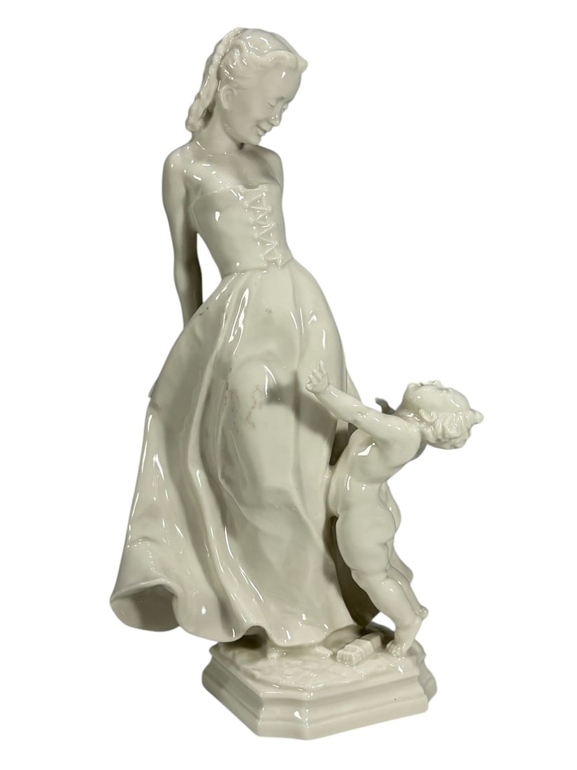 Hutschenreuther Selb Mother & Child Figurine: Hutschenreuther Selb Bavaria Germany porcelain figurine depicting an elegant mother figure in flowing dress with a child reaching upward at her side. Finished in glossy white porcelain with sculptural