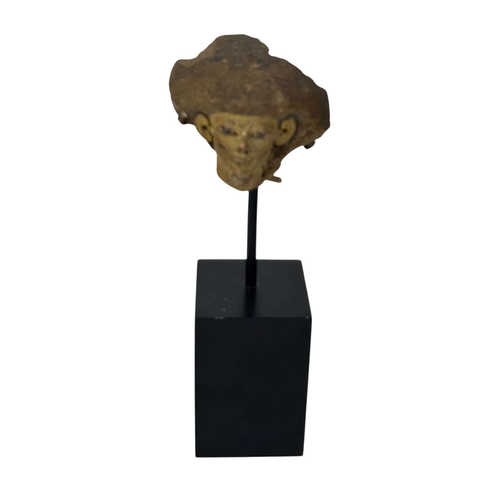 Ancient Style Terracotta Pottery Head Fragment: Ancient style terracotta fragment depicting a head with tall headdress and stylized facial features. Mounted on a black colored rectangular base on a metal display stand. Dimensions: 7.25 X 2 X 2 in.