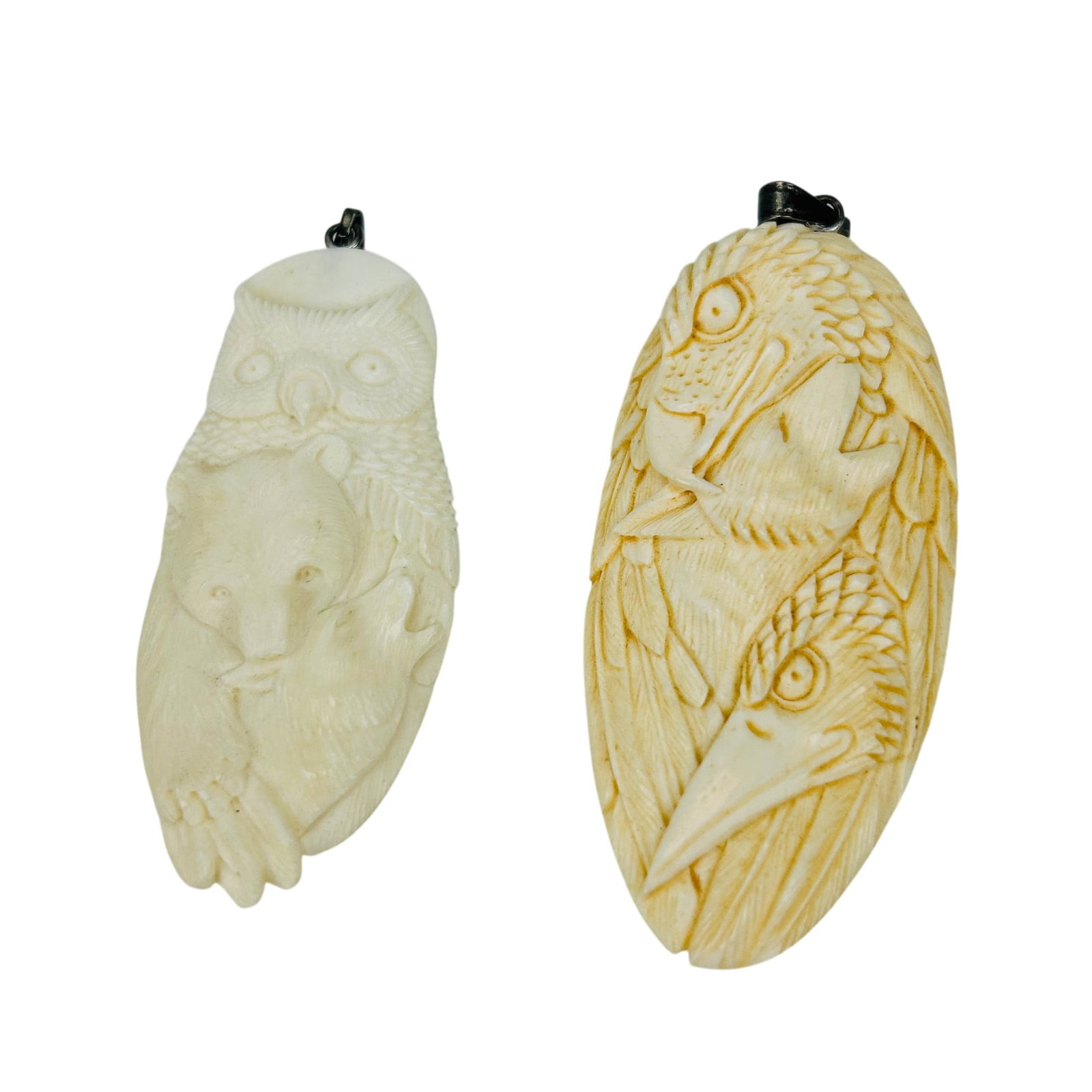 Carved Bird & Animal Oval Necklace Pendants 2pc: Two necklace pendants carved from naturally occurring material. One depicting an owl, a bear and a wolf, the other features birds of prey and a coyote. Each fitted with a metal suspension bail for