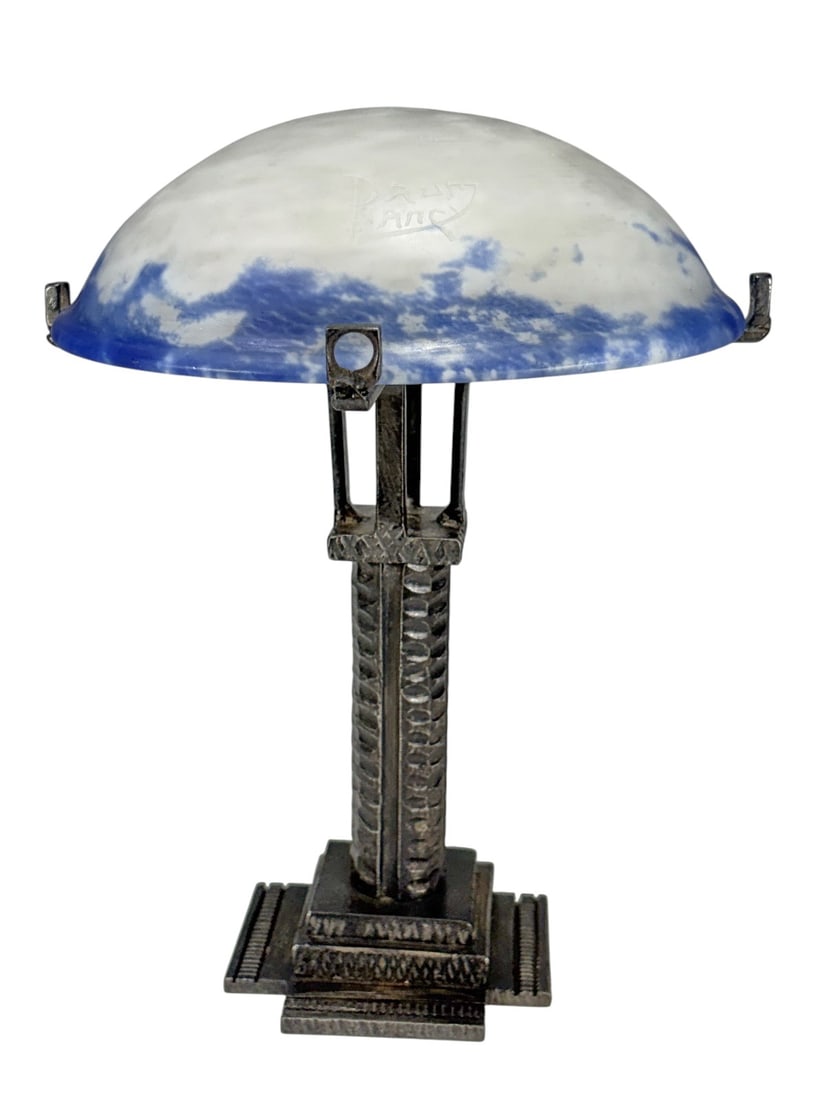 Daum Nancy Glass Shade Art Deco Iron Lamp Base: Art Deco table lamp featuring a frosted art glass shade with blue mottled decoration, signed Daum Nancy. The shade is mounted on a sculptural wrought iron base with hammered finish and stepped geometr