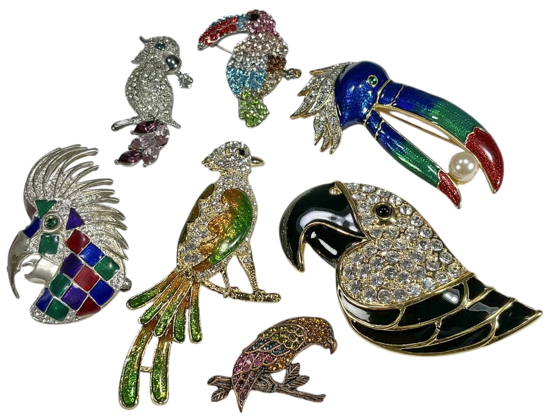 Assorted Colorful Figural Bird Brooches Pins 7pcs: Group of seven figural bird-form costume jewelry brooches featuring colorful tropical and stylized bird designs. The lot includes toucans, parrots, and other exotic birds decorated with enamel, rhines