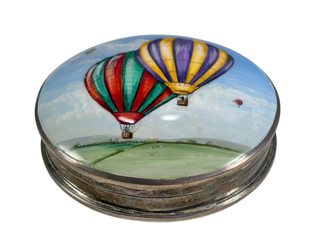 English Sterling Silver Enamel Balloon Pill Box: English sterling silver pill box with domed enamel lid depicting colorful hot air balloons over a landscape. Hinged circular form with hand-painted enamel decoration and fully hallmarked sterling silv