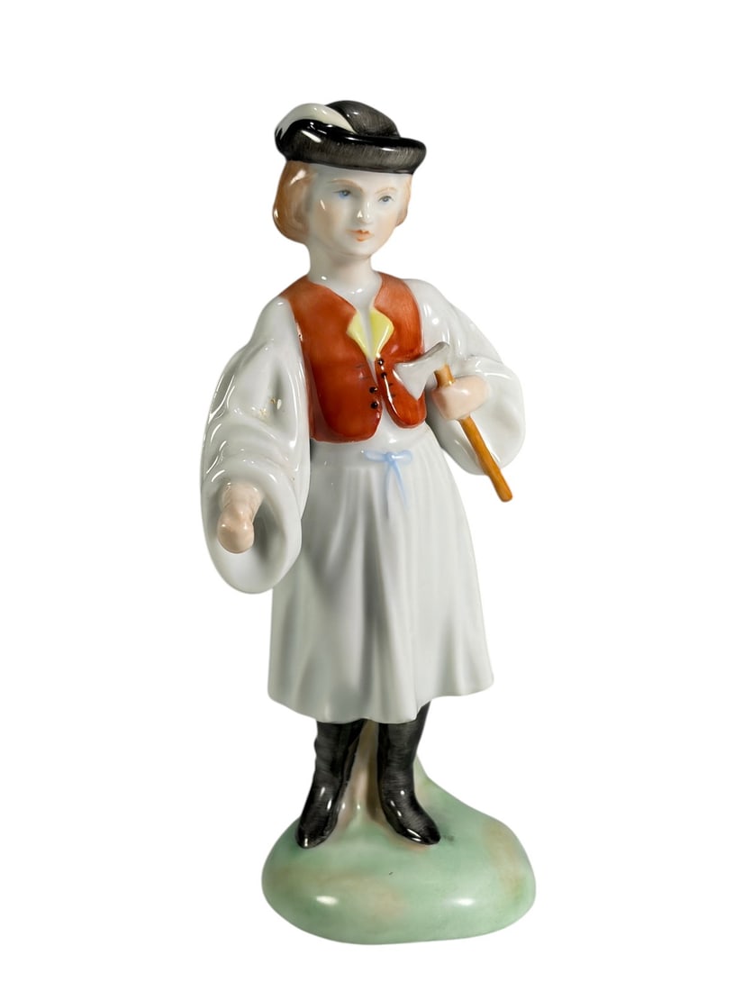 Herend Hand Painted Porcelain Peasant Boy Figure: Herend Hungary hand-painted porcelain figurine depicting a young boy in traditional folk attire holding an axe. Standing on a green molded base and decorated in Herend's distinctive style. Underside m