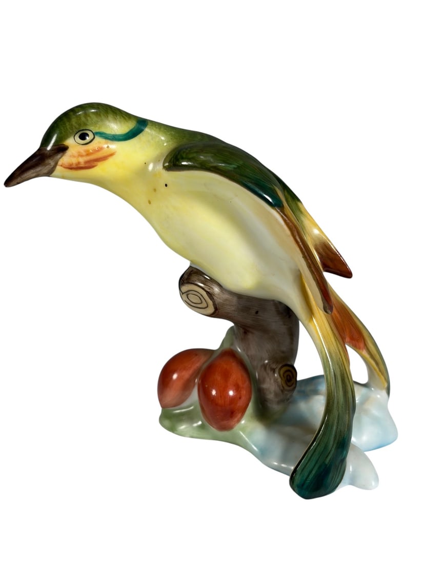 Herend Hungary Porcelain Bird on Branch Figurine: Hand-painted Herend Hungary porcelain bird figurine perched on a tree stump with red berries and pale blue ground. The bird is decorated in shades of green, yellow, cream, and brown with finely detail
