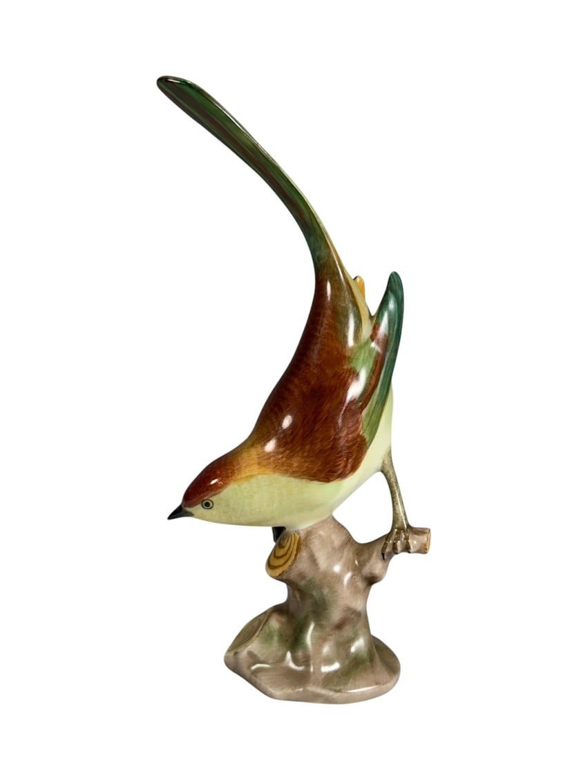 Herend Hungary Hand Painted Porcelain Bird Fig: Hand painted Herend Hungary porcelain bird figurine perched on a naturalistic tree stump base. The bird features vibrant red-orange, green, yellow, and cream coloration with an elongated tail and fine