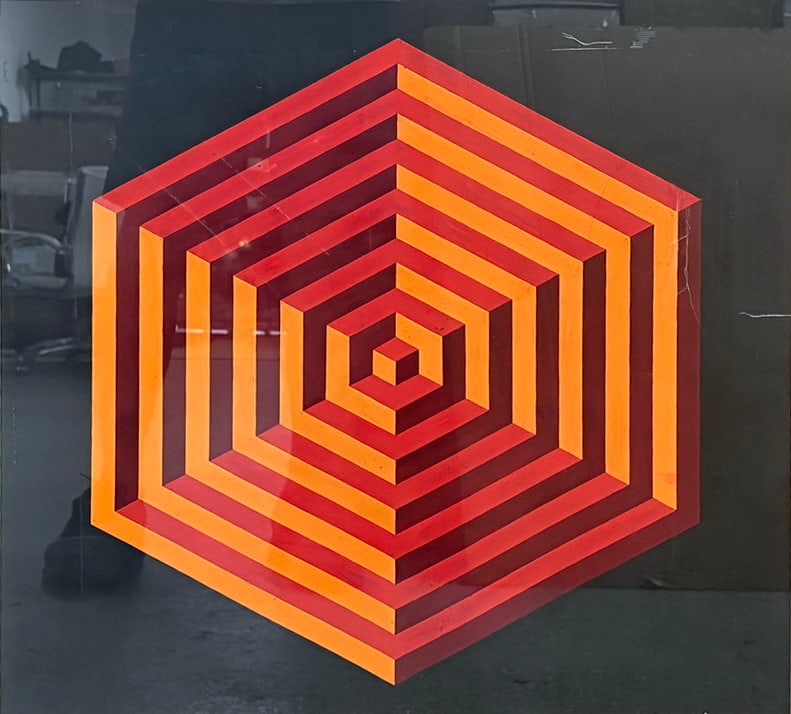 After V. Vasarely Op Art Geometric Work Serigraph: Framed serigraph after Victor Vasarely featuring a concentric hexagonal geometric composition rendered in vivid shades of orange, red, and burgundy against a black ground. The bold color contrasts and