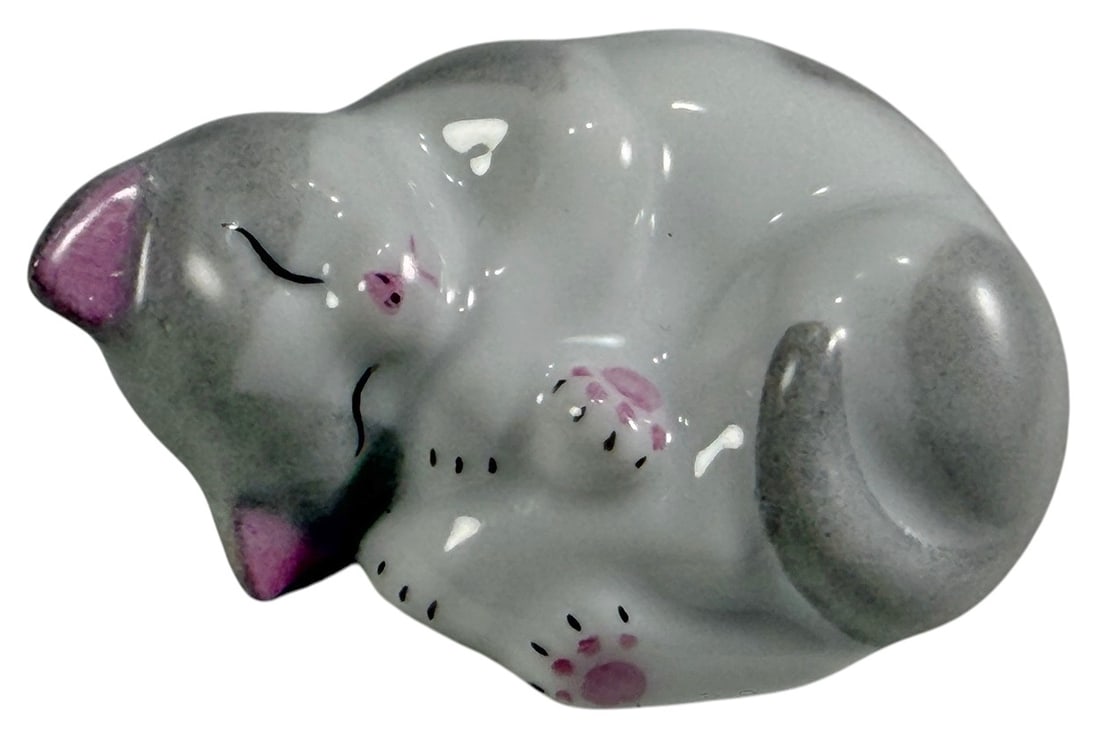 Herend Hungary Sleeping Kitten Porcelain Figurine: Hand painted Herend Hungary porcelain figurine depicting a sleeping kitten curled into a resting position. The figure features soft gray and white coloration with pink inner ears, pink paw pads, and d