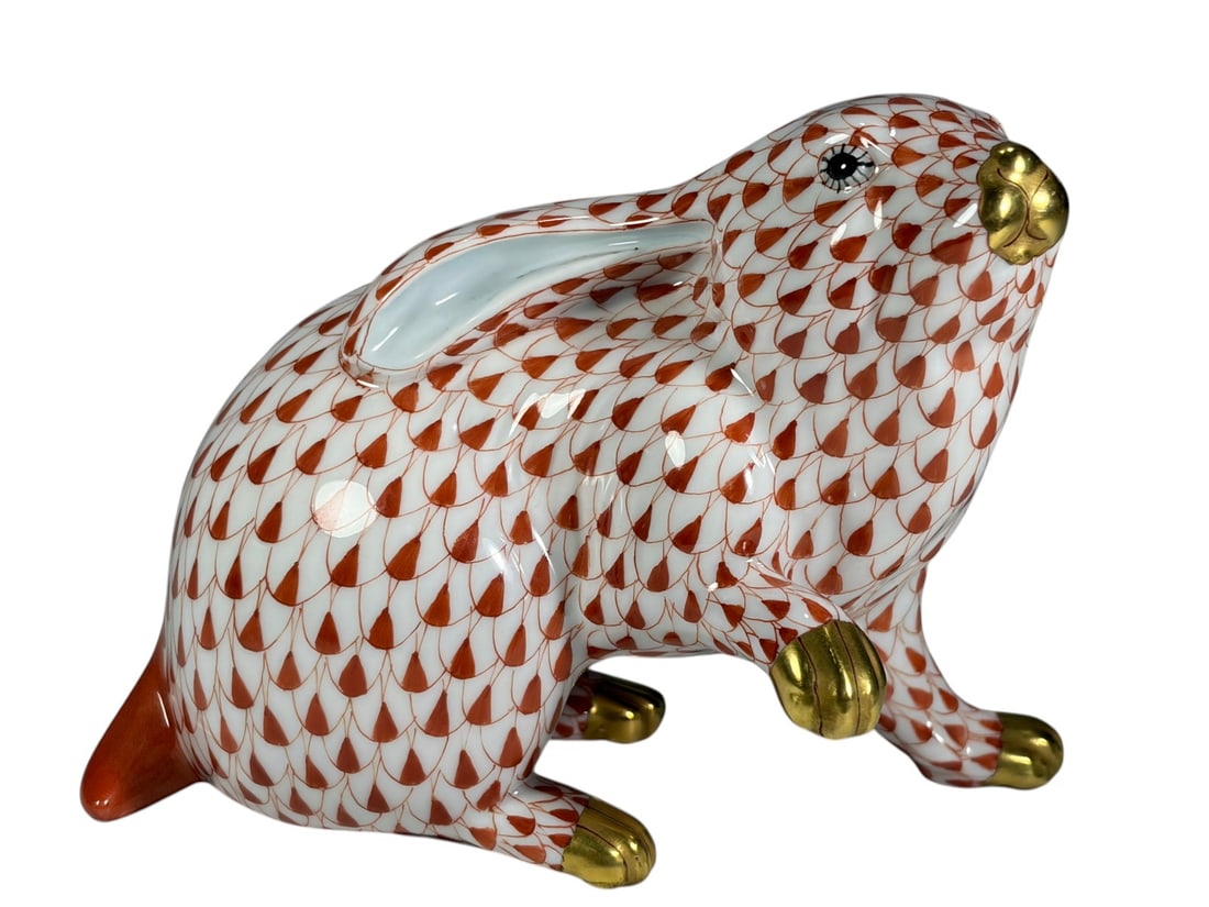 Herend Hungary Fishnet Rust Seated Rabbit Figurine: Herend Hungary handpainted porcelain rabbit figurine decorated in the classic rust fishnet pattern with gilt accented paws and nose. The rabbit is modeled in an alert seated pose with raised forepaw, 