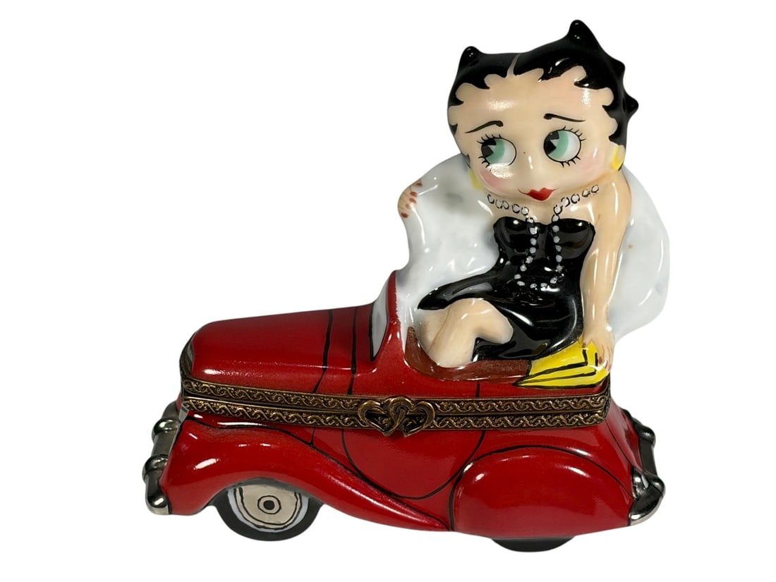 Limoges Betty Boop Trinket Box Automobile Theme: Porcelain Limoges collector trinket box titled "Out on the Town" featuring Betty Boop seated on a red automobile. Hand-painted and fitted with gilt metal hinged mount and clasp in the form of intertwi