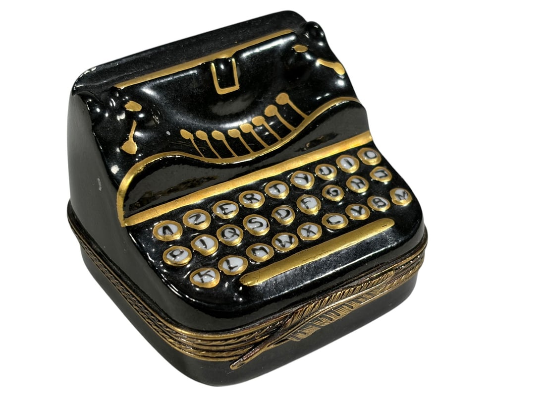 Limoges France Porcelain Typewriter Trinket Box: Hand-painted Limoges porcelain trinket box modeled as a vintage black typewriter with detailed keyboard, carriage, and gilt accents. The hinged box opens to reveal a white porcelain interior with a sm