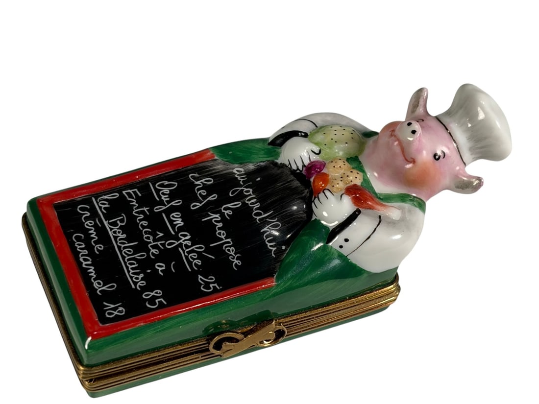 Rochard Limoges France Chef Menu Trinket Box Gold: Hand-painted Rochard Limoges porcelain trinket box modeled as a French restaurant menu board topped by a chef figure holding vegetables. The front is decorated with a chalkboard-style menu written in 