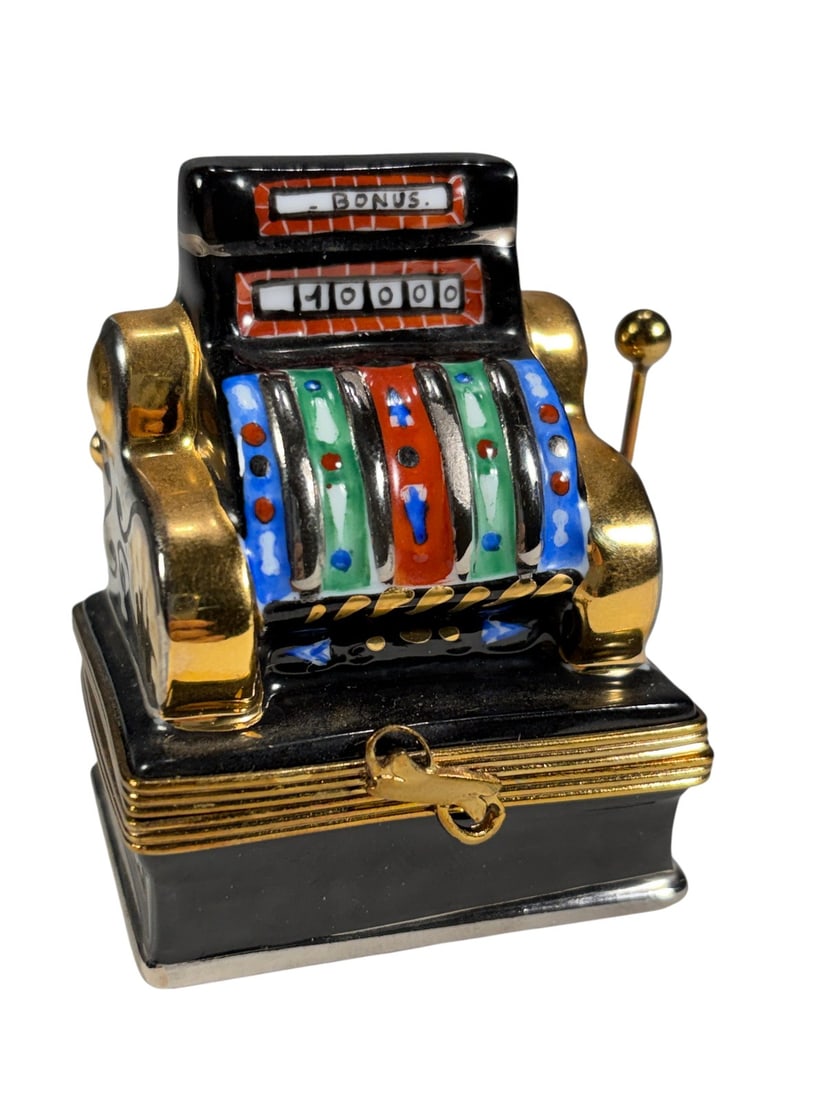 Rochard Limoges France Slot Machine Trinket Box: Hand-painted Rochard Limoges porcelain trinket box modeled as a vintage slot machine with colorful reels, coin lever, and gilt accents. The figural design captures the appearance of a classic casino s