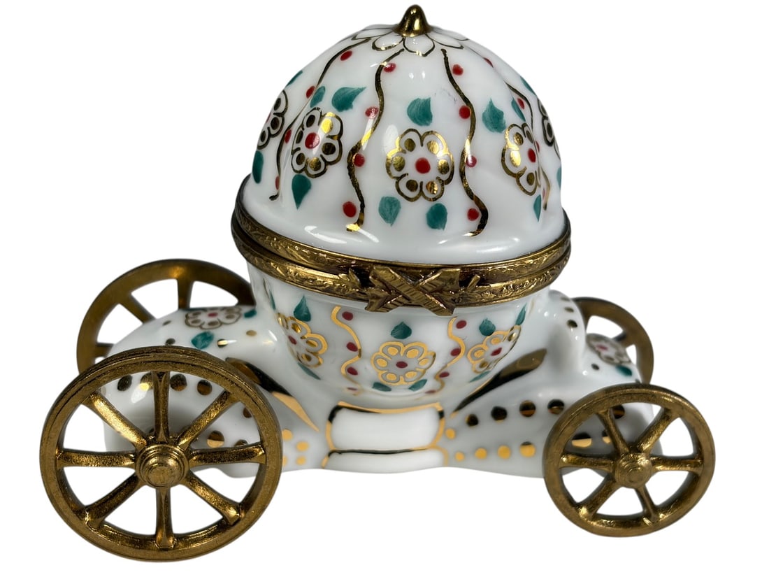 Limoges France Porcelain Cinderella Trinket Box: Hand-painted Limoges porcelain trinket box modeled as Cinderella's pumpkin coach with four metal wheels and floral decoration accented in gold. The hinged coach opens to reveal a porcelain interior an