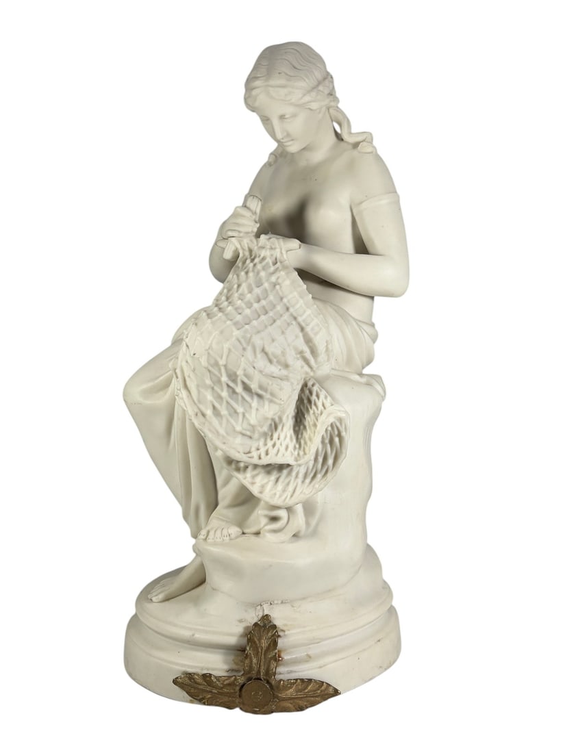J&TB Biscuit Porcelain Woman Knitting Figure Bust: Biscuit porcelain figural sculpture depicting a seated young woman knitting. Executed in matte white finish with detailed modeling of the figure, drapery, and knitted textile. Mounted on an oval base 