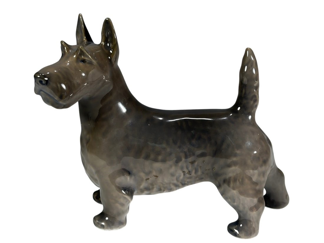 Royal Copenhagen Porcelain Terrier Dog Figurine: Royal Copenhagen porcelain terrier dog figurine, model number 3101. Depicts a standing terrier with raised tail and alert ears, finished in soft gray and cream glaze tones. Marked on the underside wit
