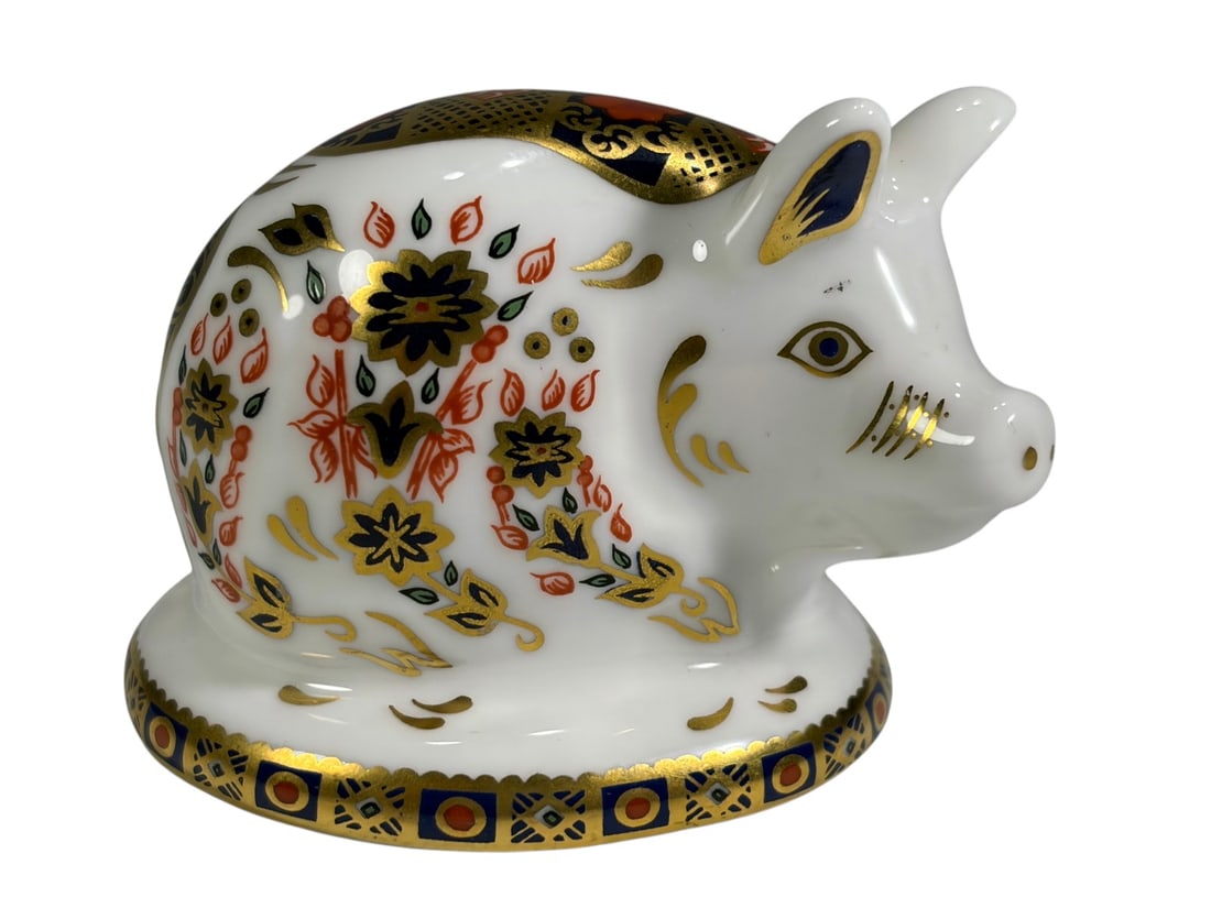 Royal Crown Derby Imari Pig Porcelain Paperweight: Royal Crown Derby porcelain pig paperweight decorated in the traditional Imari palette with rich cobalt blue, iron red, black, and extensive hand-applied gilt decoration. The seated pig is adorned wit