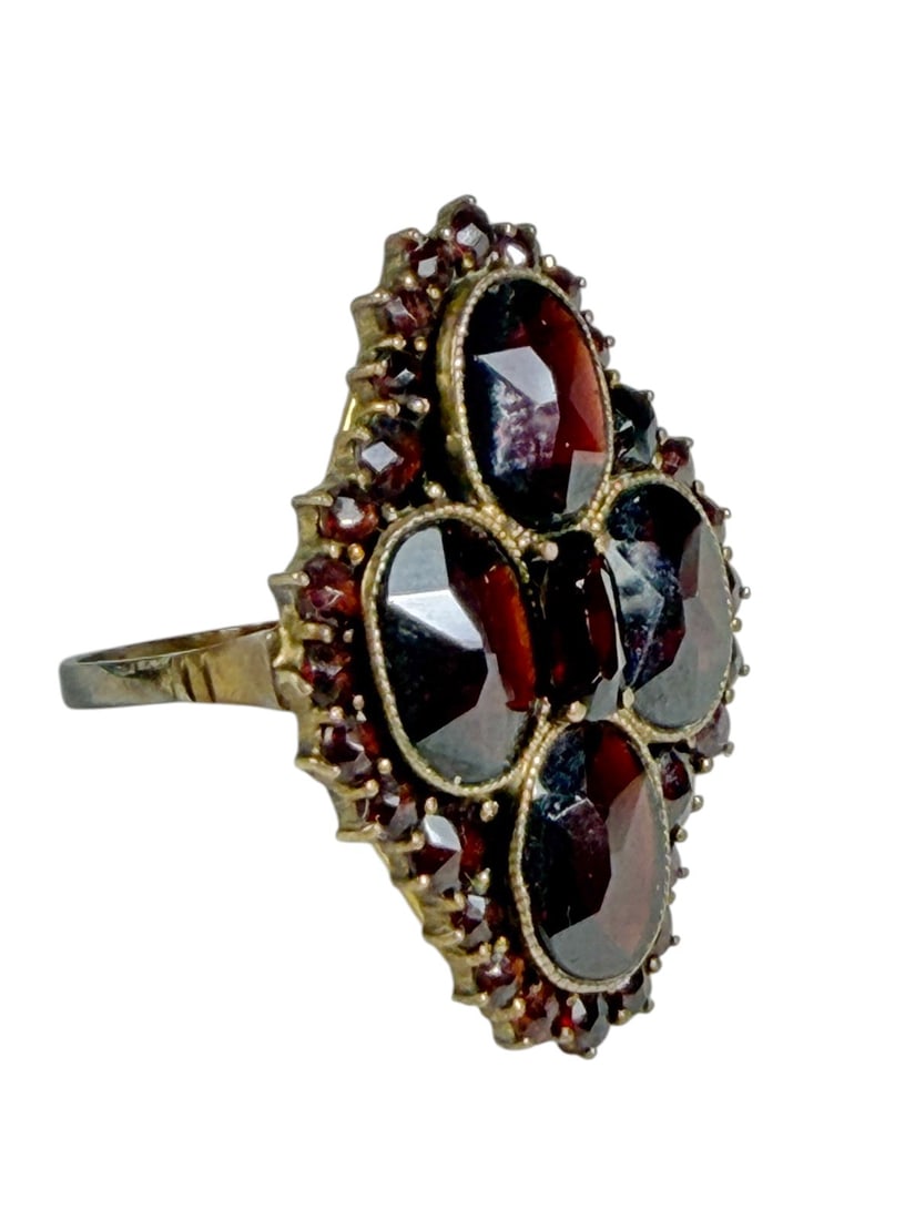 Antique Bohemian Garnet Cluster Ring Gold Setting: Antique Bohemian garnet cluster ring featuring four large oval garnets surrounded by a border of smaller faceted garnets. Mounted in a yellow gold setting with open-back construction typical of late 1