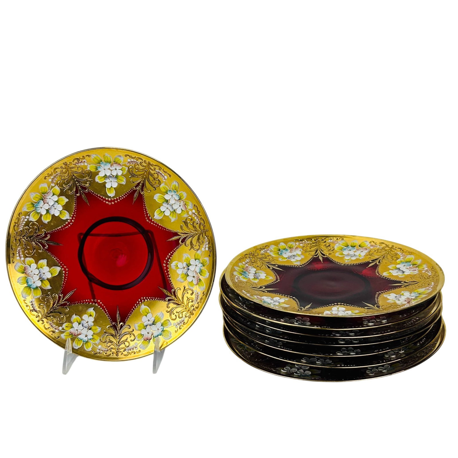 Bohemian Ruby Red Glass Floral Enamel Plates 8pc: Lot of eight Bohemian Czech crystal ruby red glass plates comprising assorted sizes. Floral enamel motifs, gilt scrollwork, beaded borders, and star form reserves decorate each example. Measurements r