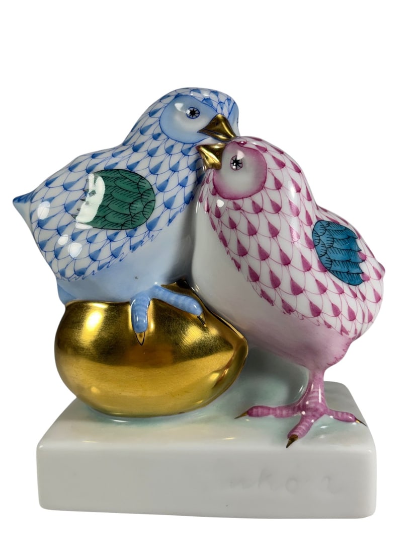 Herend Hungary Love Chicks Porcelain Figurine Pair: Herend Hungary hand-painted porcelain figurine depicting a pair of love birds perched together on a gilt accent. Decorated in Herend's signature fishnet pattern with blue and pink plumage, green wings