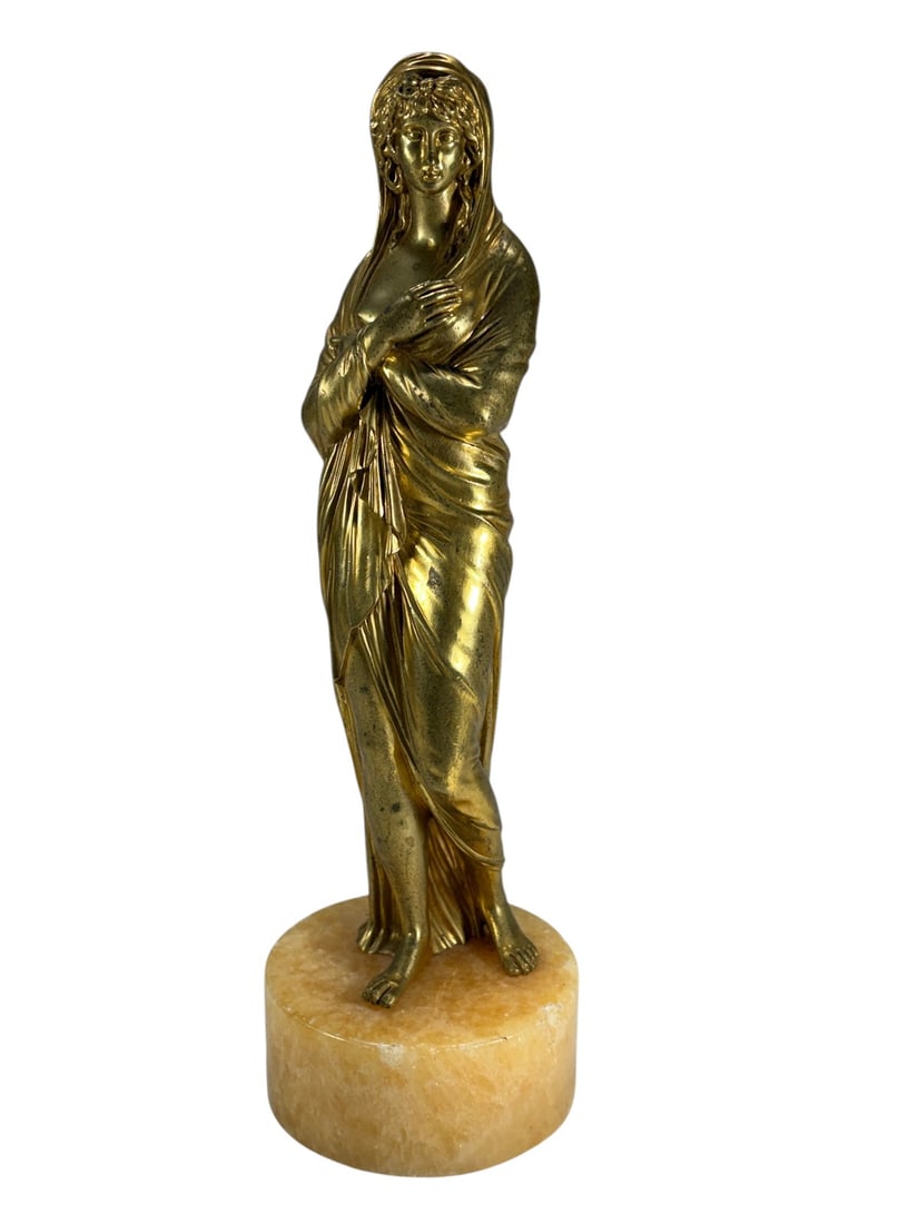 Classical Gilt Bronze Female Figure Onyx Base: Classical style gilt bronze female figure draped in flowing robes and standing on a polished onyx base. Finely cast with detailed facial features and drapery folds, making it a decorative tabletop scu