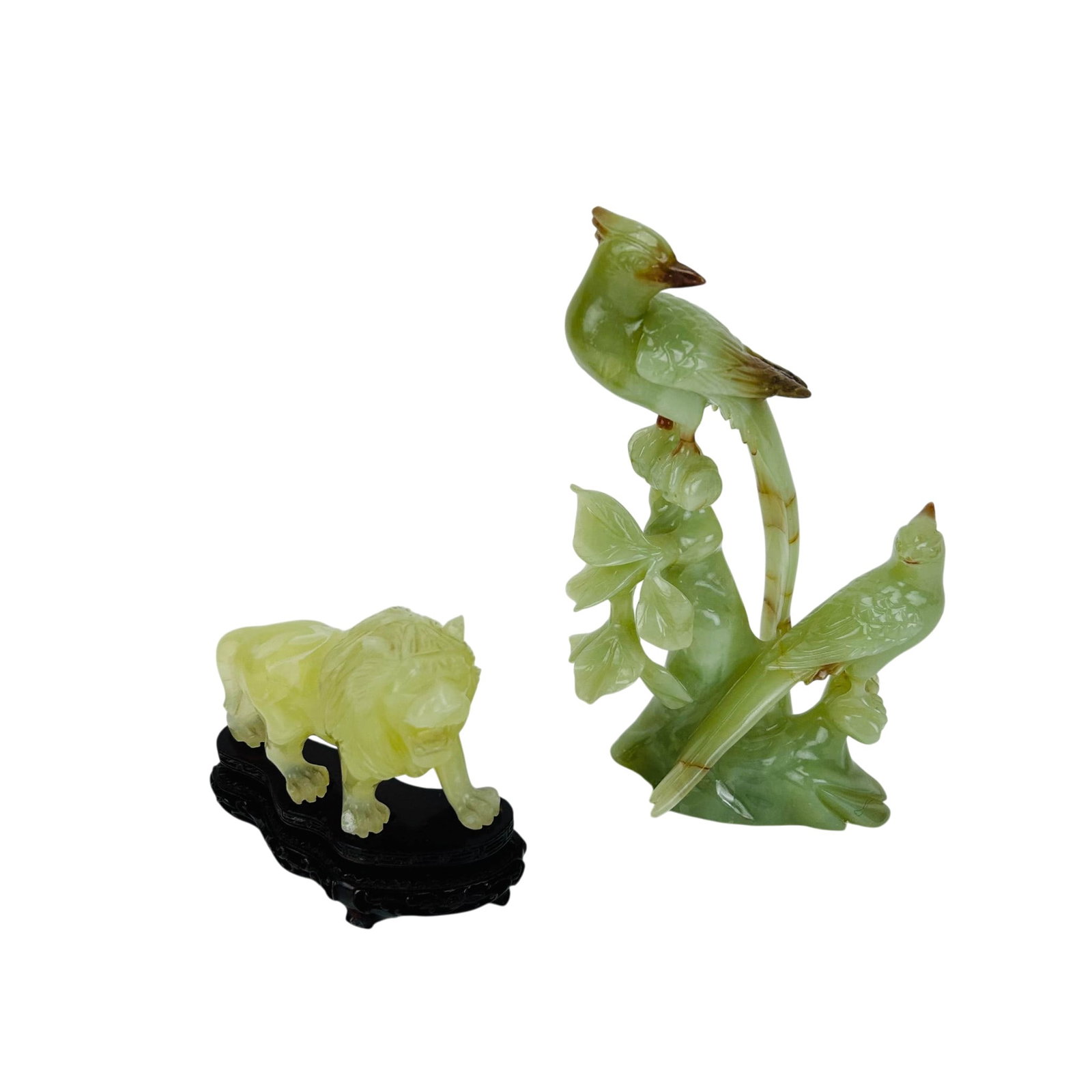 Chinese Export Jade Style Birds and Lion 2pc LOT: Estate lot of two Chinese hardstone carved figural sculptures. Includes a group depicting two birds perched among foliage and a recumbent lion figure raised on a carved wood display stand. Both exampl