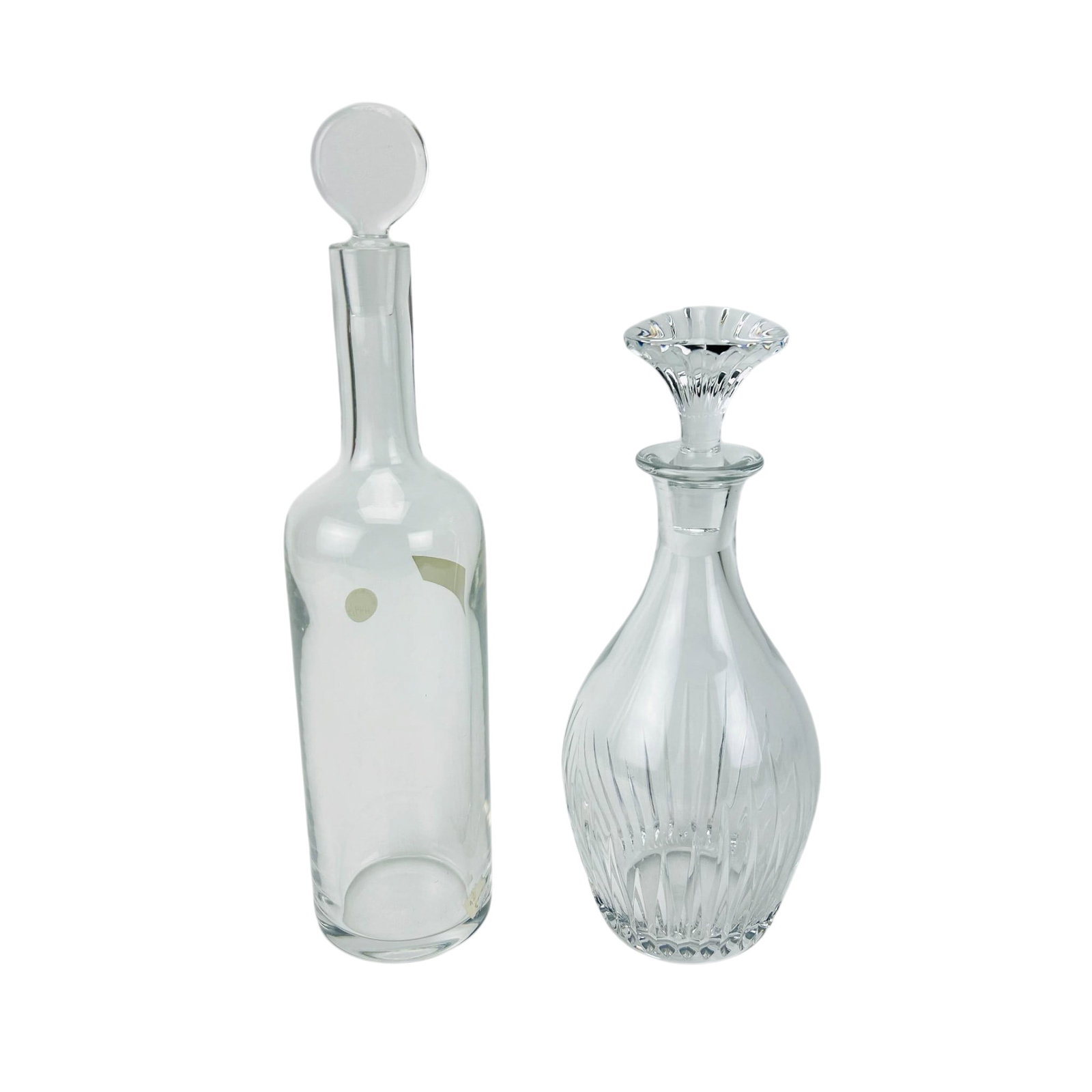 Baccarat Massena & Dyonisos Crystal Decanter LOT: Lot of two French crystal barware decanters. The Dyonisos example features a cylindrical form with a ball form stopper, retaining a Baccarat label. The Massena pattern showcases a ribbed body and face