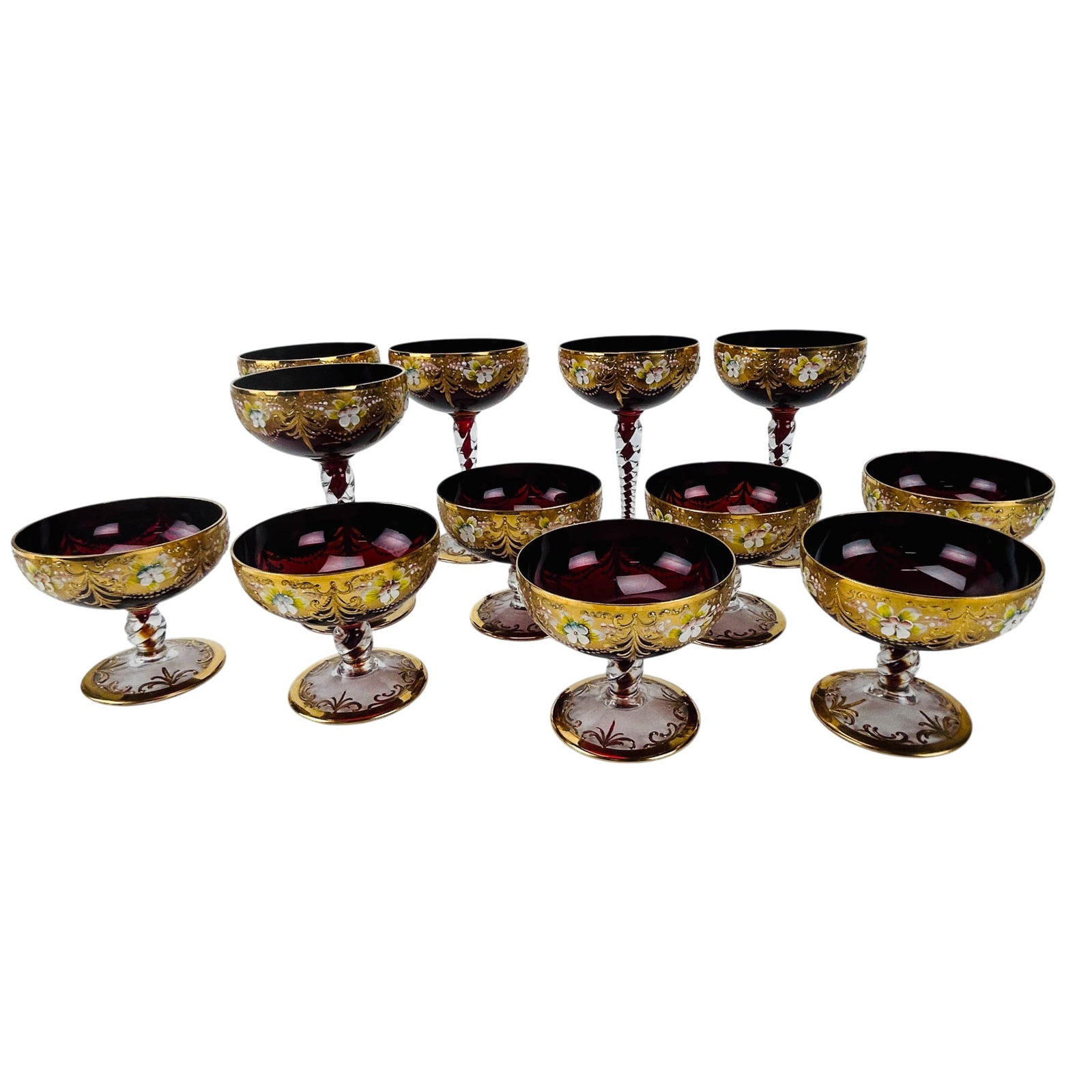 12 Bohemian Ruby Red Enamel & Gilt Sherbet Glasses: Bohemian Czech crystal barware champagne sherbet glasses, estate lot of twelve, having two different sizes. Each features a deep ruby bowl with extensive gilt decoration accented by hand painted polyc