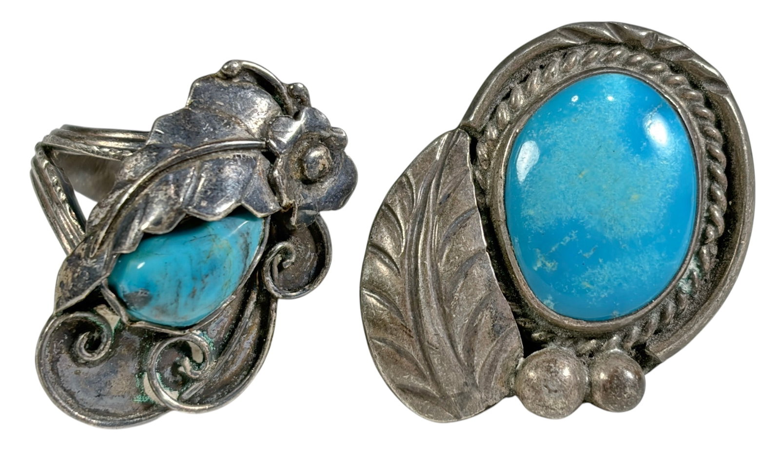 Sterling Silver Turquoise Stone Rings 15.9g 2pcs: Two sterling silver rings featuring natural turquoise cabochons in handcrafted Southwestern style settings. One ring displays an oval turquoise stone with leaf motif accents, while the other features 