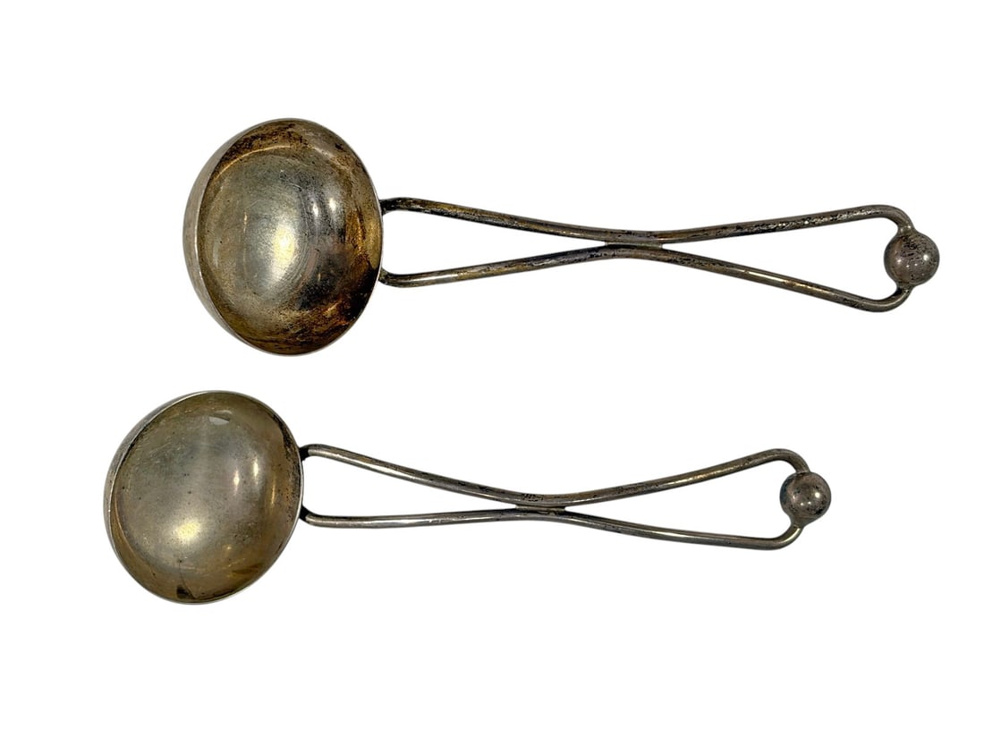 Mid-Century Cartier Sterling Silver Jam Ladles 2pc: Lot of two vintage Cartier sterling silver jam ladles featuring a Mid-Century Modern design with loop handles and ball finials. Both are marked Cartier and sterling. Combined weight is approximately 4