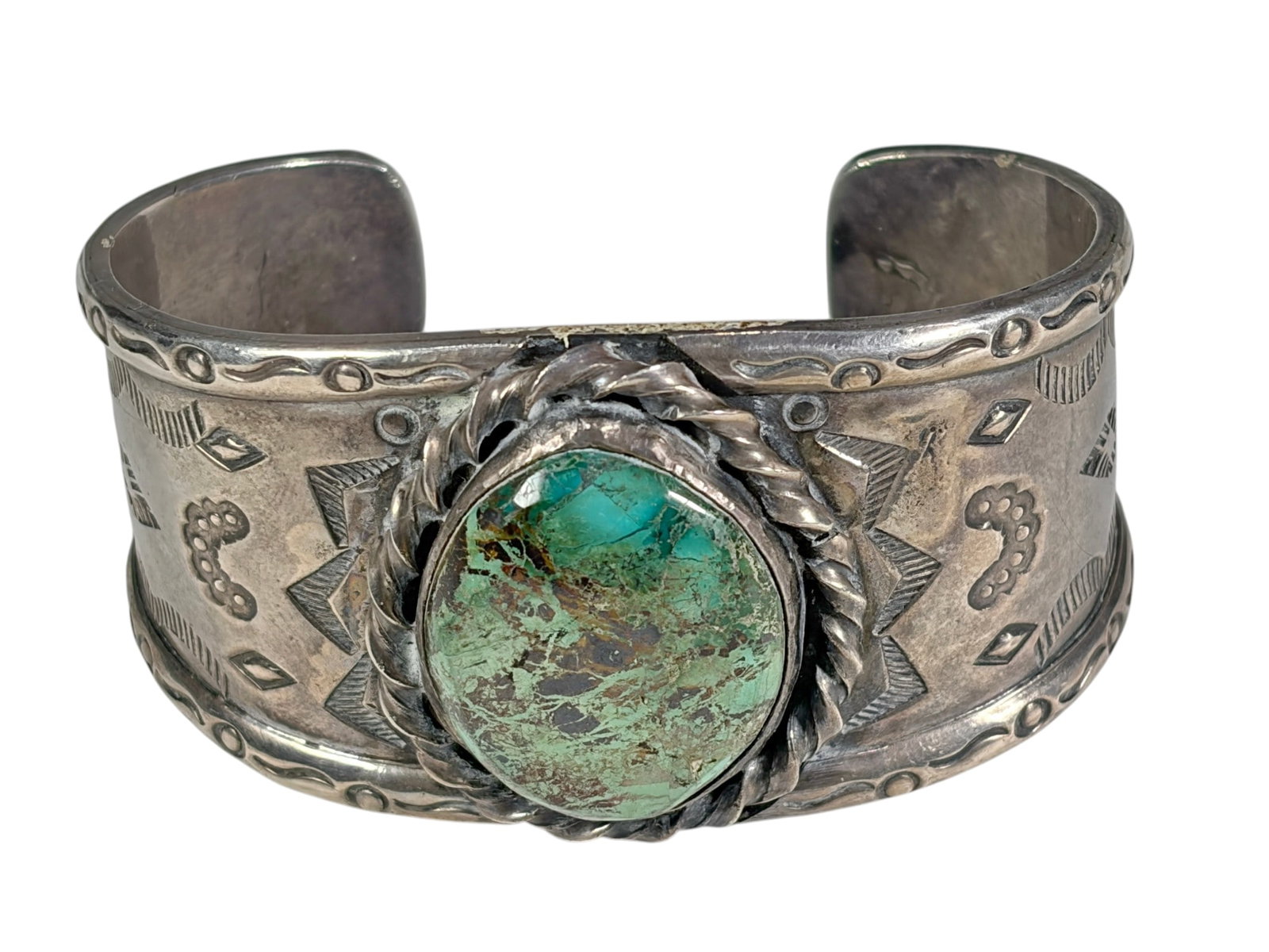 Mexican 925 Sterling Turquoise Cuff Bracelet 93.6g: Mexican sterling silver cuff bracelet featuring a large oval turquoise cabochon in a twisted rope bezel. The wide cuff is decorated with hand-stamped Southwestern geometric and scroll motifs along the