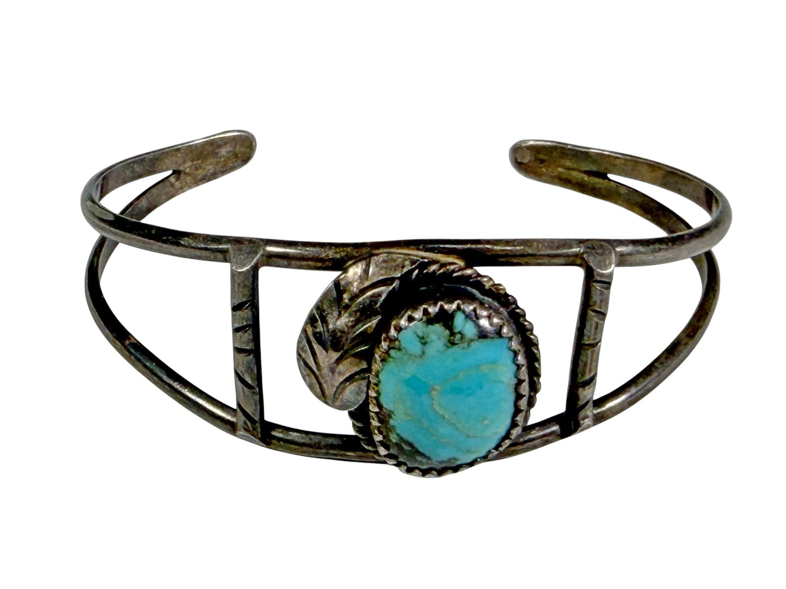 Sterling Turquoise Openwork Cuff Bracelet 13.8g: Vintage sterling silver cuff bracelet featuring an oval turquoise cabochon in a serrated bezel with rope twist border and applied leaf accent. The openwork cuff is formed with double bands joined by v