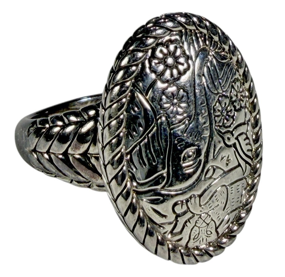 Thai Sterling Silver Figural Ring Size 10 15 Grams: Sterling silver ring featuring an engraved figural and floral motif in an oval bezel. Marked Thailand on the reverse. The ring weighs 15.0 grams and is a U.S. size 10. Includes the green JAI John Hard