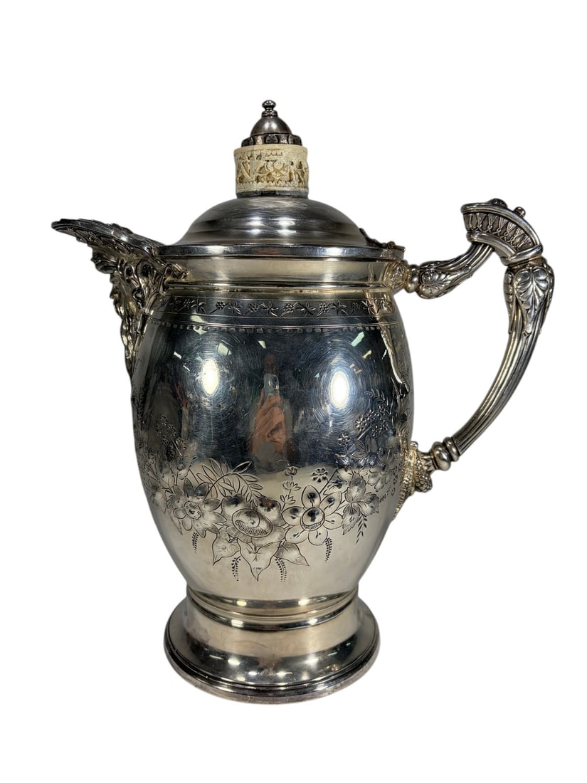 Meriden Silverplated Chocolate Pot With Bone Finia: Antique Meriden Britannia Company silverplated chocolate pot featuring engraved floral decoration, ornate figural handle and spout mounts, and a domed lid with a carved bone finial. The interior is li