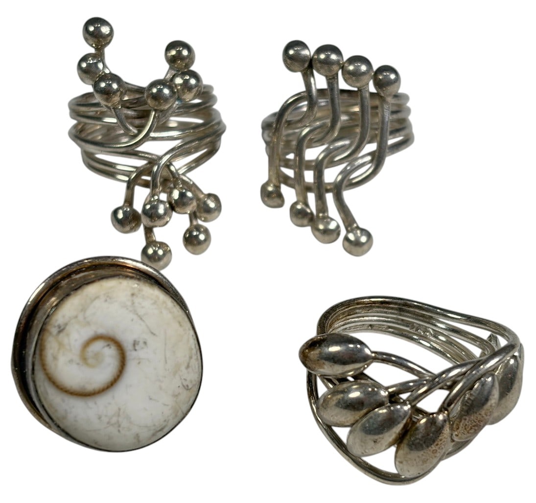 Modern Sculptural Sterling Silver Mixed Rings 4pcs: Lot of 4 sterling silver rings featuring contemporary sculptural designs. Includes one ring set with a Shiva eye shell, one with polished teardrop elements, and two abstract openwork designs with poli