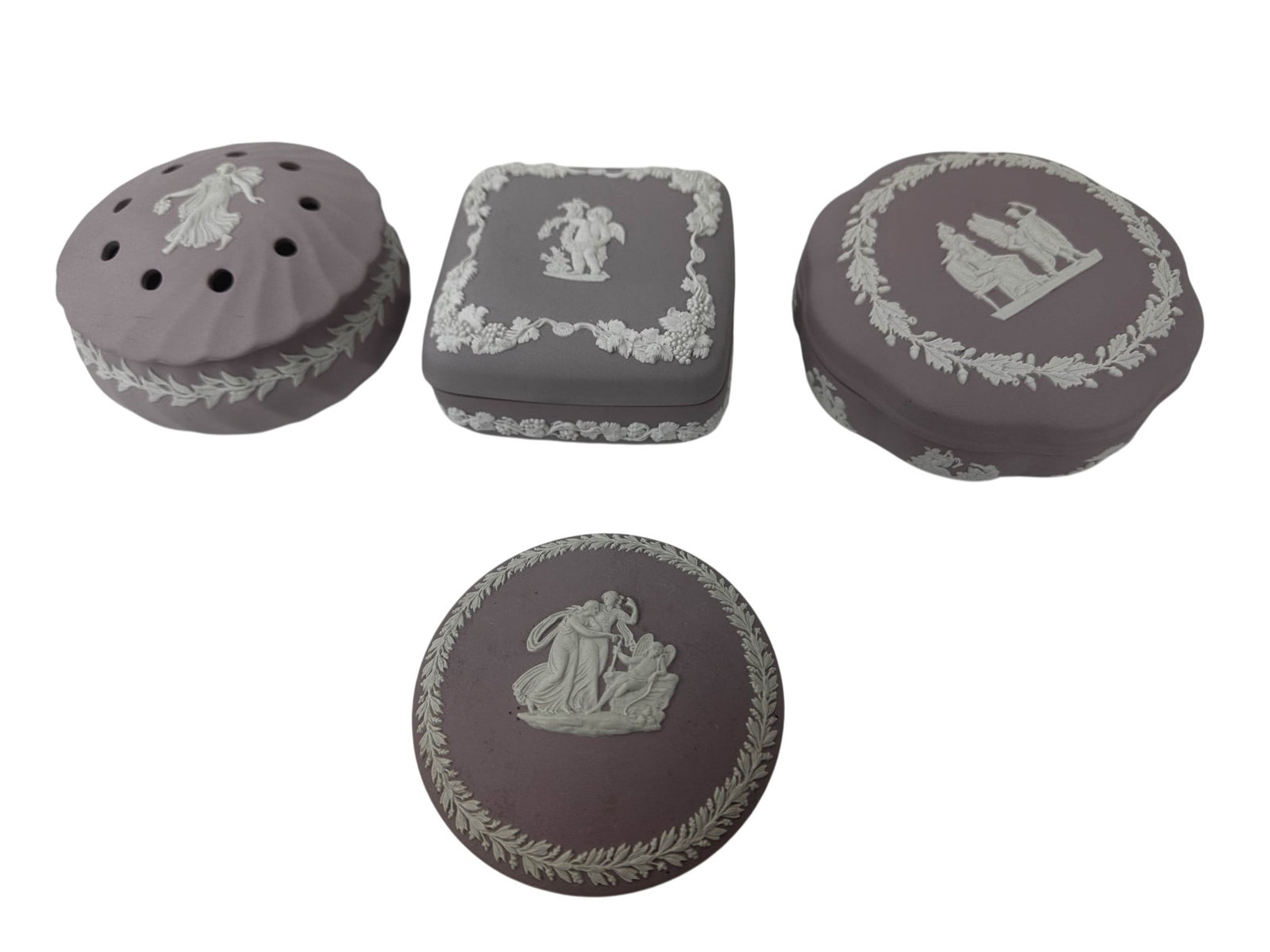 Wedgwood Lilac Jasperware Trinket & Potpourri Box: Group of four Wedgwood England Lilac jasperware decorative articles comprising three covered trinket jewelry coin storage boxes and a potpourri jar. Each piece features white applied Neoclassical reli