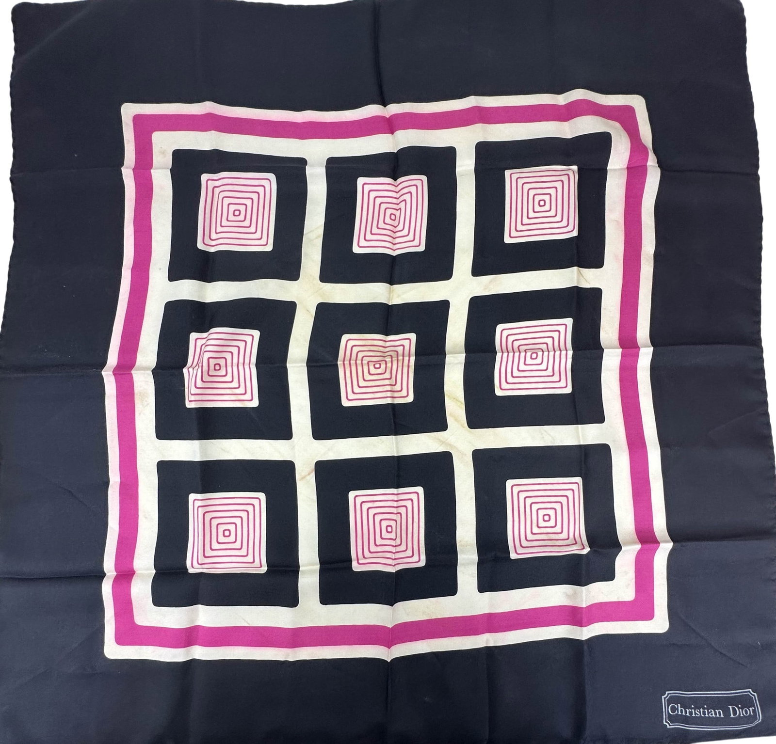 Christian Dior Geometric Designer Silk Scarf: Christian Dior silk square scarf featuring an abstract geometric pattern of concentric squares in black, white, and pink with hand rolled edges. Dior signature appears within the border. Dimensions: 2