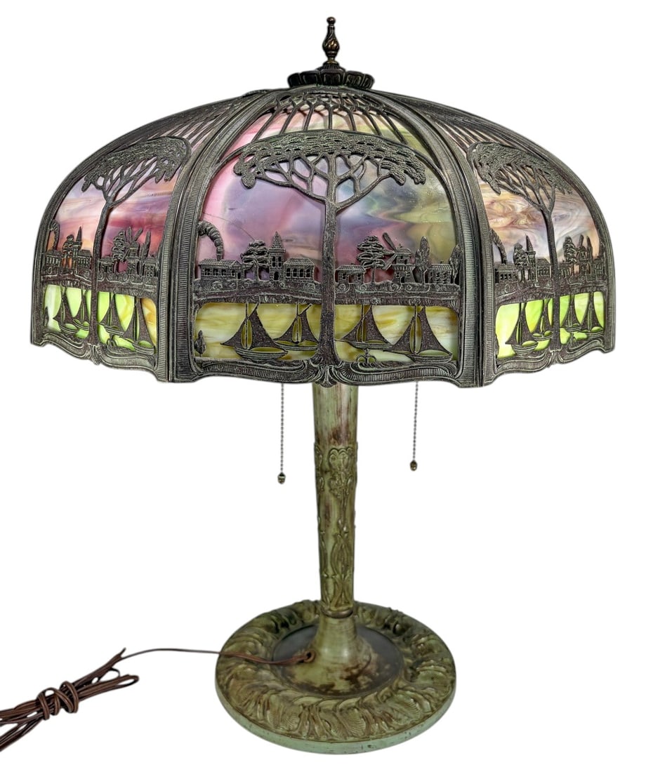 Miller Style Art Nouveau Scenic Glass Table Lamp: Miller style Art Nouveau table lamp featuring a domed slag glass shade with a scenic landscape motif including sailboats, trees, buildings, and windmills in relief. The lamp has a cast metal base with