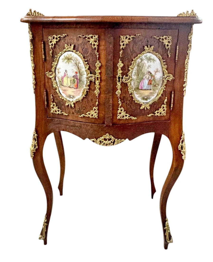 French Louis XV Style Burl Ormolu Mounted Cabinet: French Louis XV style cabinet featuring shaped sides, burl wood veneer panels, and gilt bronze ormolu mounts throughout. The two front doors are inset with hand-painted porcelain plaques depicting rom