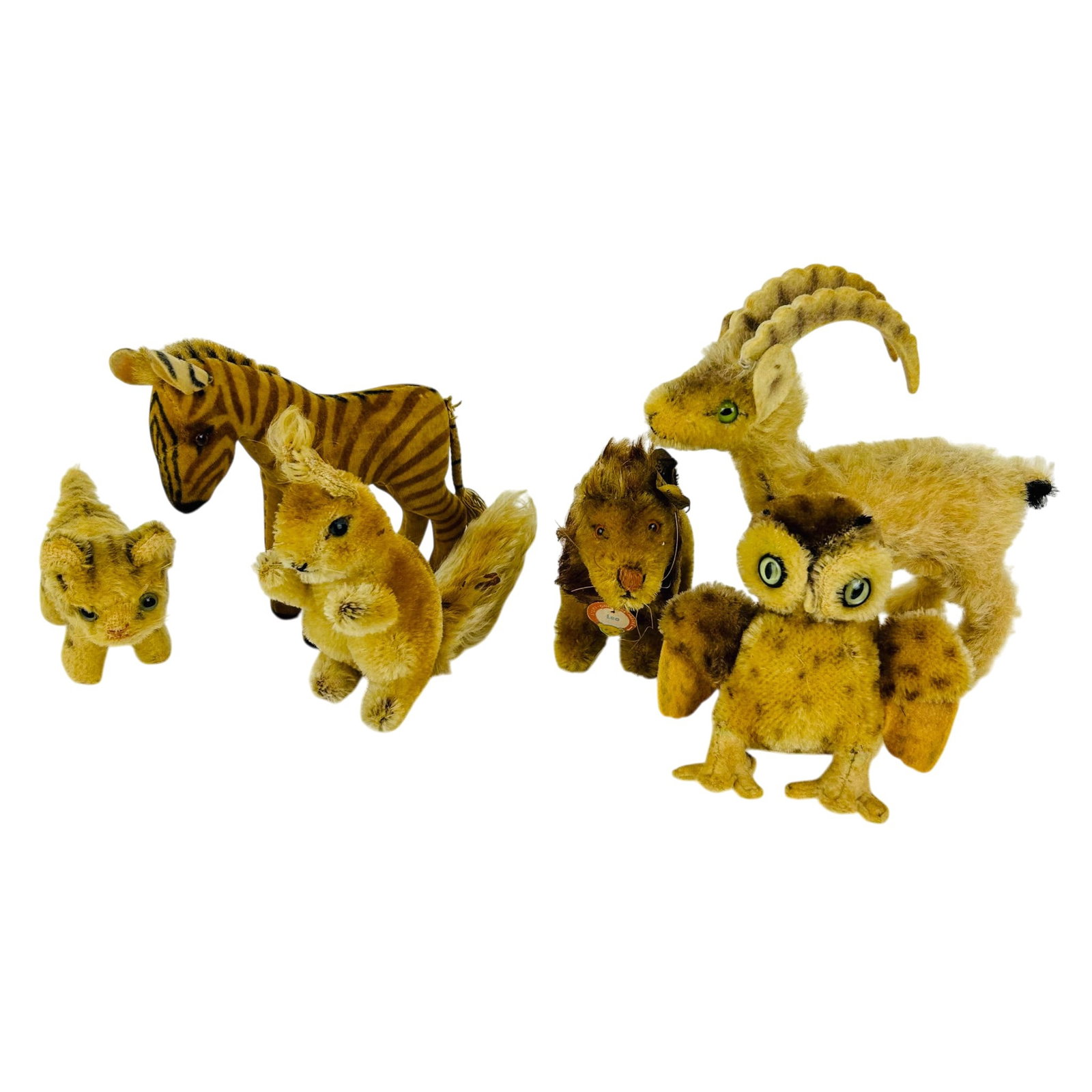 Steiff Lion Zebra Squirrel Owl Ibex & Kitten LOT: Group of six stuffed animal figures including Steiff examples. Lot comprises a lion retaining partial ear tag, zebra, owl, ibex with molded horns, squirrel and kitten. Constructed of mohair and plush 