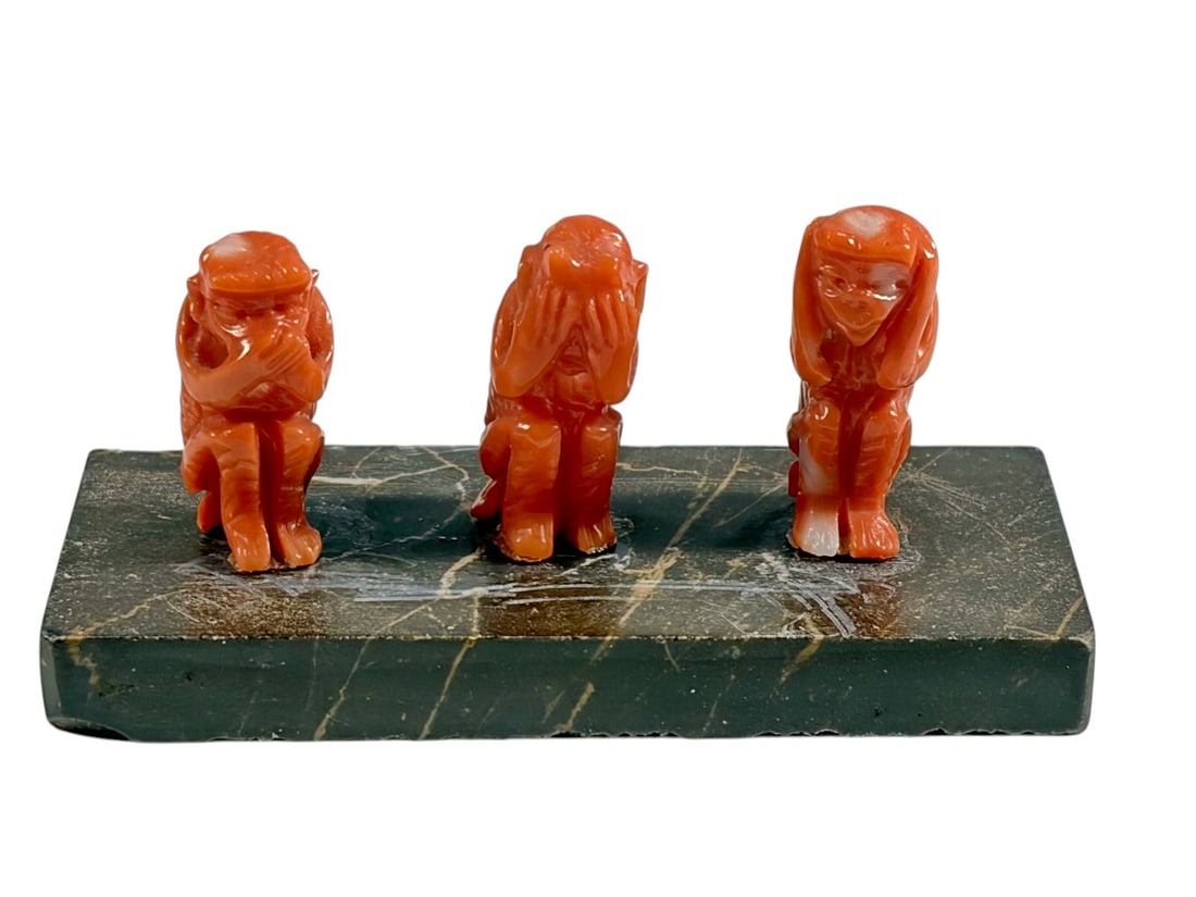 Three Wise Monkeys Coral on Portoro Marble Base: Decorative sculpture depicting the Three Wise Monkeys in carved coral resting on a polished Portoro marble base. The figures are not attached to the base and simply rest on top. Representing the tradi