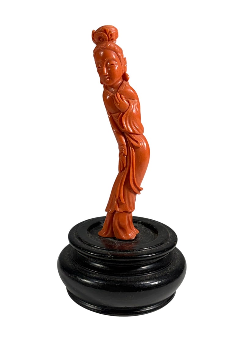 Carved Red Coral Asian Lady Figure on Wood Base: Carved red coral figure depicting an elegant Asian lady in flowing robes with an elaborate coiffure, mounted on a turned black wood display base. The figure displays natural white inclusions character