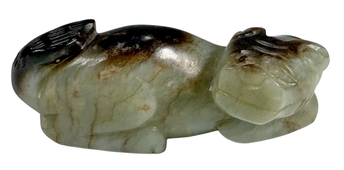 Chinese Nephrite Jade Mythical Beast Carving Figur: Chinese nephrite jade carving depicting a recumbent mythical beast with its head turned to the side. Carved from a single piece of pale jade with natural dark russet inclusions accentuating the sculpt