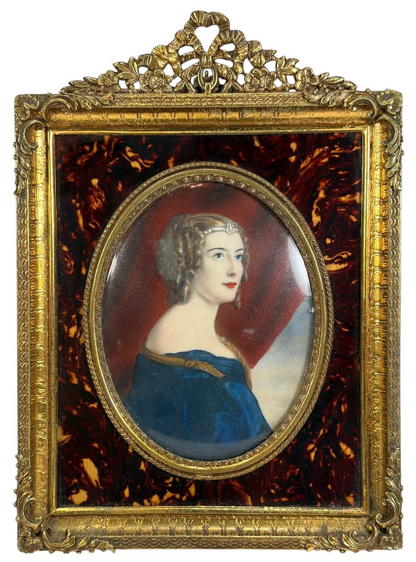 Hand Painted Portrait Miniature in Bronze Frame: Hand-painted portrait miniature depicting an elegantly dressed young woman in a blue gown, mounted beneath convex glass within an ornate gilt bronze easel frame featuring a faux tortoiseshell surround
