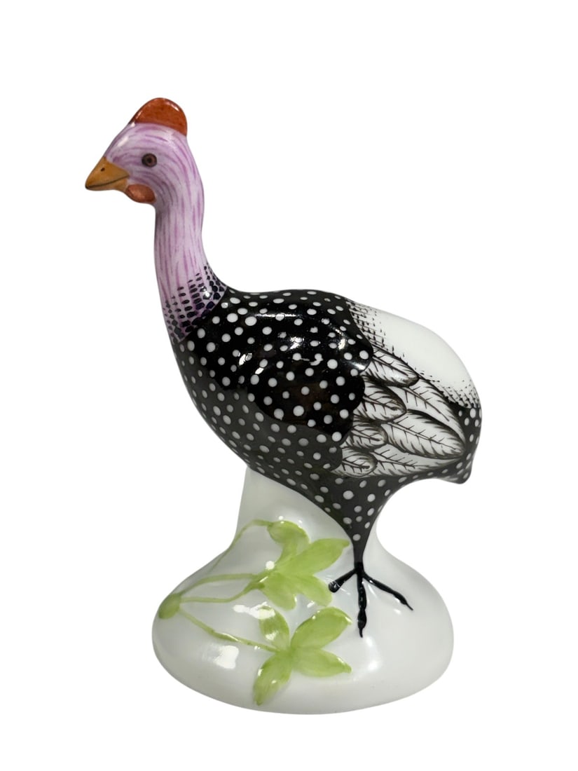 Herend Hungary Guinea Fowl Porcelain Figurine Bird: Herend Hungary hand-painted porcelain guinea fowl figurine with finely detailed black and white plumage, a lavender neck, and orange beak and comb, standing on a white base with green foliage. Marked 