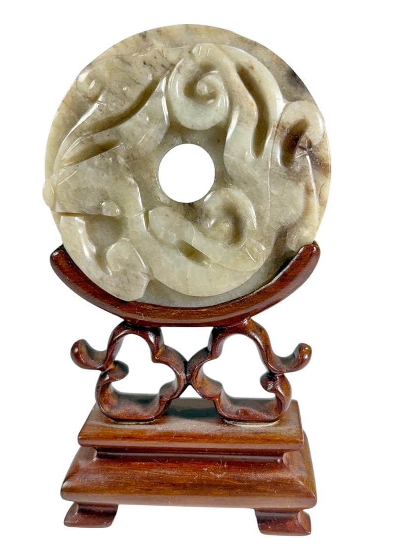 Chinese Celadon Jade Chilong Bi Disc Qing Style: Chinese celadon jade bi disc carved in open relief with intertwined chilong (young dragons) encircling the central aperture. The reverse features incised scroll decoration. The stone displays transluc